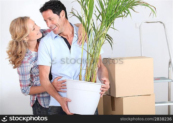 Couple smiling with plant