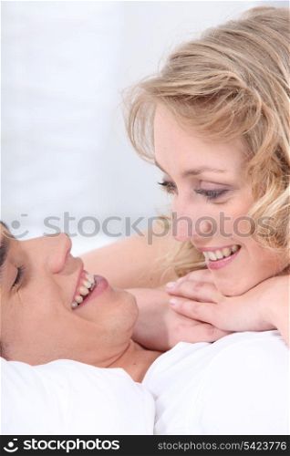 Couple snuggling in bed