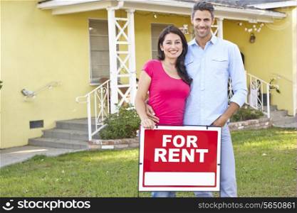Couple Standing By For Rent Sign Outside Home