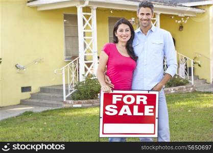 Couple Standing By For Sale Sign Outside Home