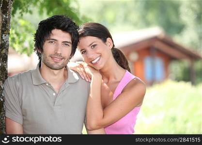 Couple standing in front of a holiday cabin