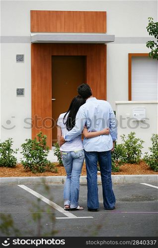 Couple standing in front of their dream home