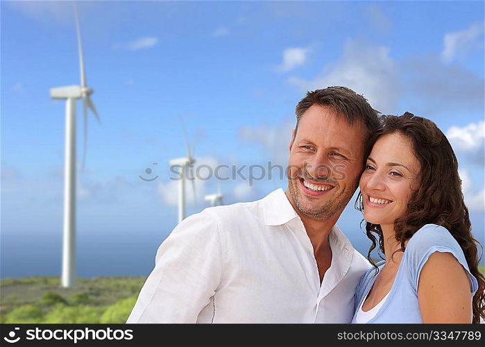 Couple standing in front of wine turbines