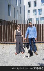 Couple standing in the city with dog. Erica Vilaro.jpg,Albert Mando.jpg