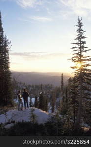 Couple Standing On A Mountain And Watching The Sun Rise