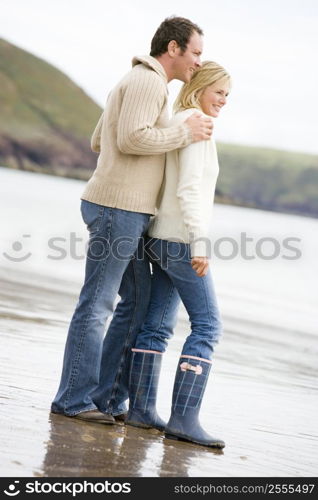 Couple standing on beach smiling