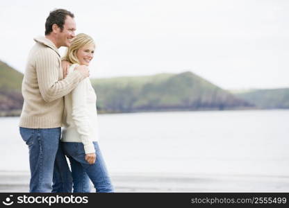 Couple standing on beach smiling