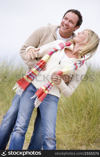 Couple standing on beach smiling