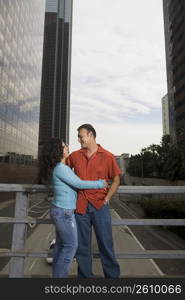 Couple standing on bridge in downtown Los Angeles