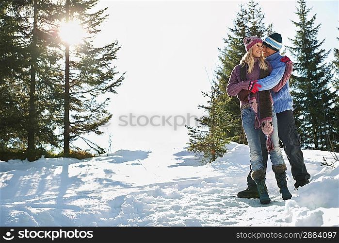 Couple standing on snow-covered hill