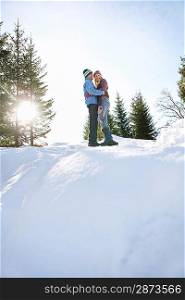 Couple standing on snow-covered hill low angle view