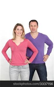 Couple standing on white background with hands on hips