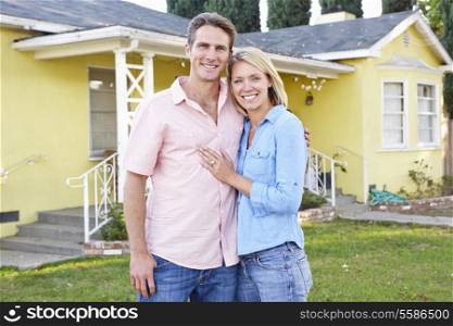 Couple Standing Outside Suburban Home