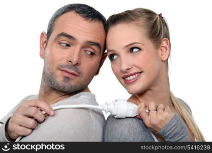 Couple stood back-to-back holding electrical cable