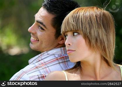 Couple stood back to back in field