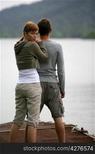 Couple stood by peaceful lake