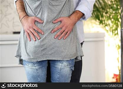 Couple stood hugging in their home