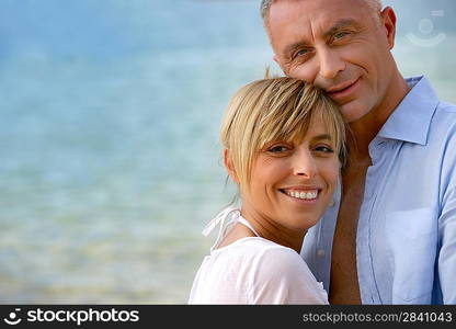 Couple stood hugging on romantic beach