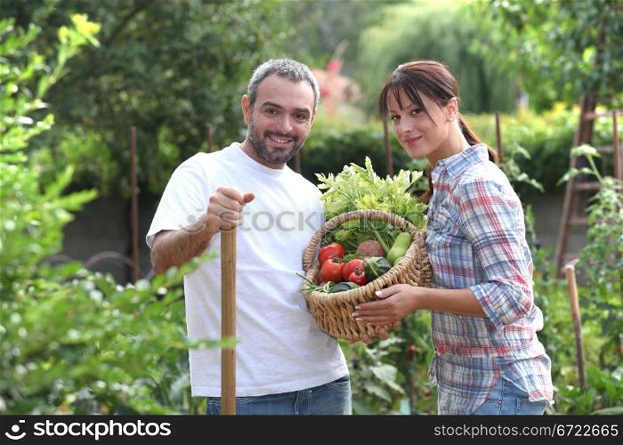 Couple stood in garden with vegetables