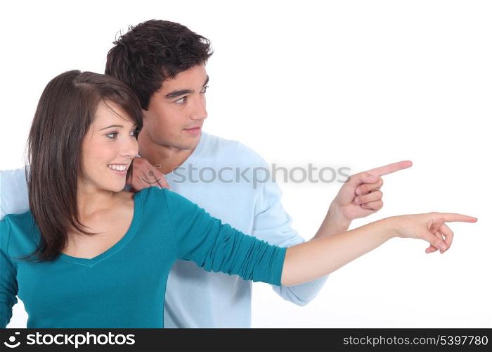 Couple stood together pointing into the distance