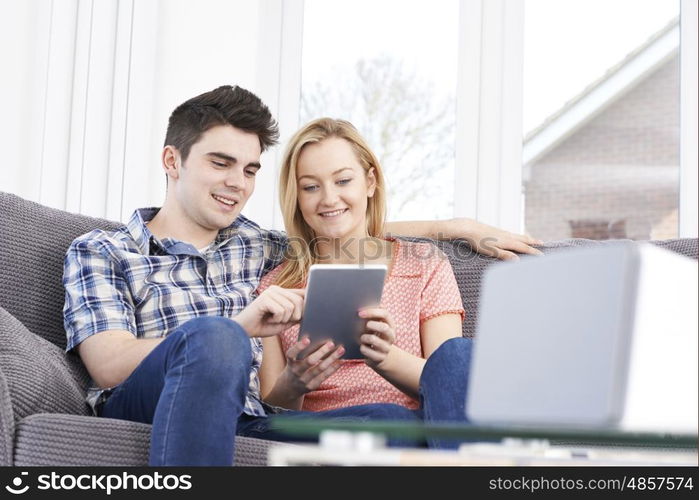 Couple Streaming Music From Digital Tablet To Wireless Speaker