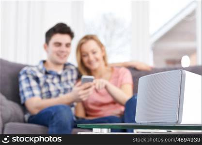 Couple Streaming Music From Mobile Phone To Wireless Speaker