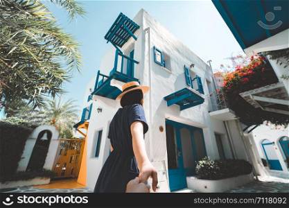 Couple summer vacation travel. Woman in blue dress and hat holding man by hand on Resort. Active, travel, tourist concepts