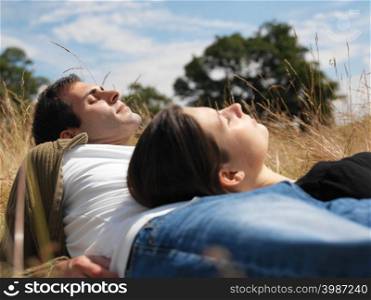 Couple sunbathing in field