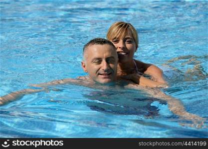 Couple swimming in hotel pool