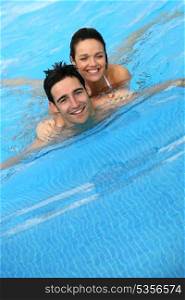 Couple swimming together in pool