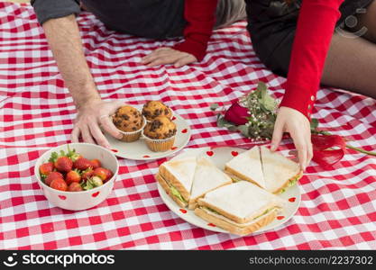 couple taking food from checkered coverlet