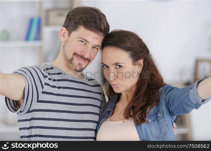 couple taking self portrait indoors