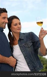 Couple tasting wine in field