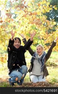 Couple throwing leaves in the air