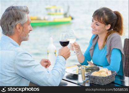 Couple toasting at riverside restaurant