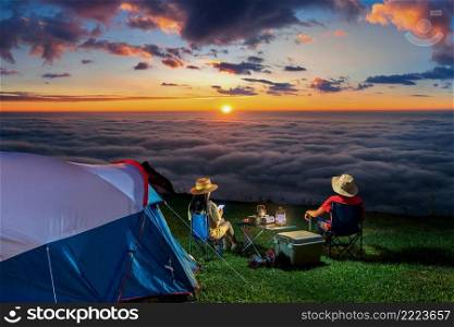 Couple tourists enjoying c&ing at sunrise on mountains.