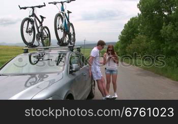 Couple traveling by car with two bicycles mounted on bike roof carrier