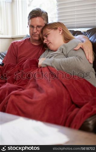 Couple Trying To Keep Warm Under Blanket At Home