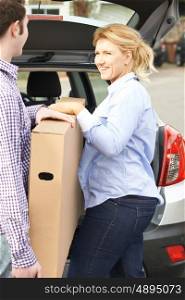 Couple Unloading New Television From Car Trunk
