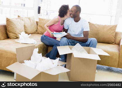 Couple unpacking boxes in new home kissing and smiling