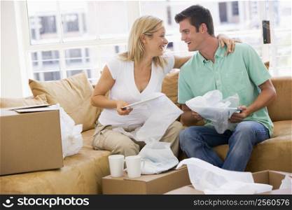 Couple unpacking boxes in new home smiling