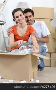 Couple unpacking fragile box