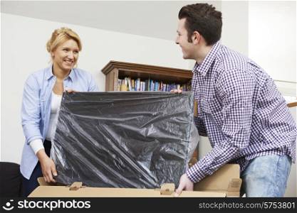 Couple Unpacking New Television At Home