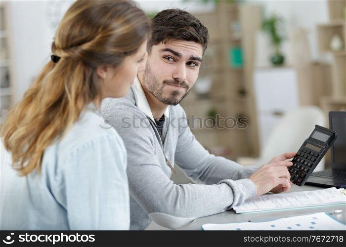 couple using a calculator to work out their finances
