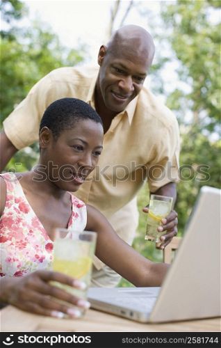 Couple using a laptop and smiling