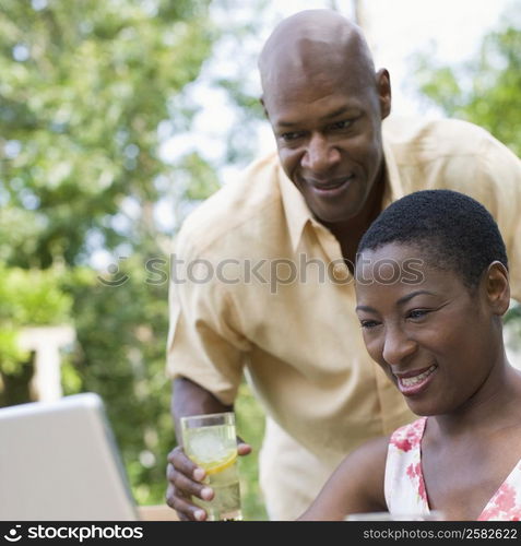 Couple using a laptop and smiling