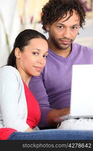 Couple using a laptop at home