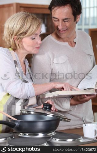 Couple using a recipe book