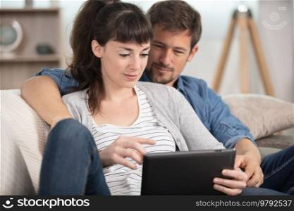 couple using a tablet computer in their living room
