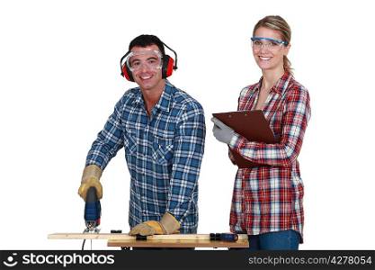 Couple using an electric jigsaw